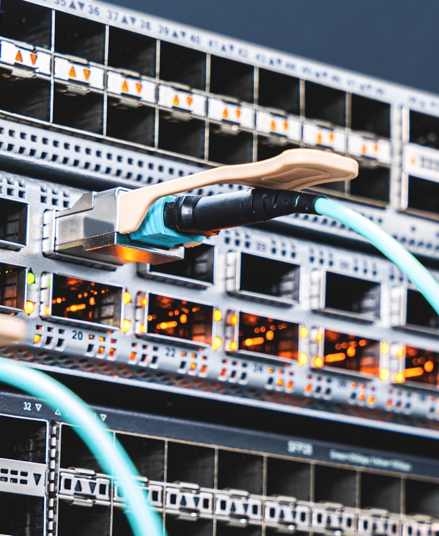 Network engineer's hand connecting a fiber uplink cable during a live migration